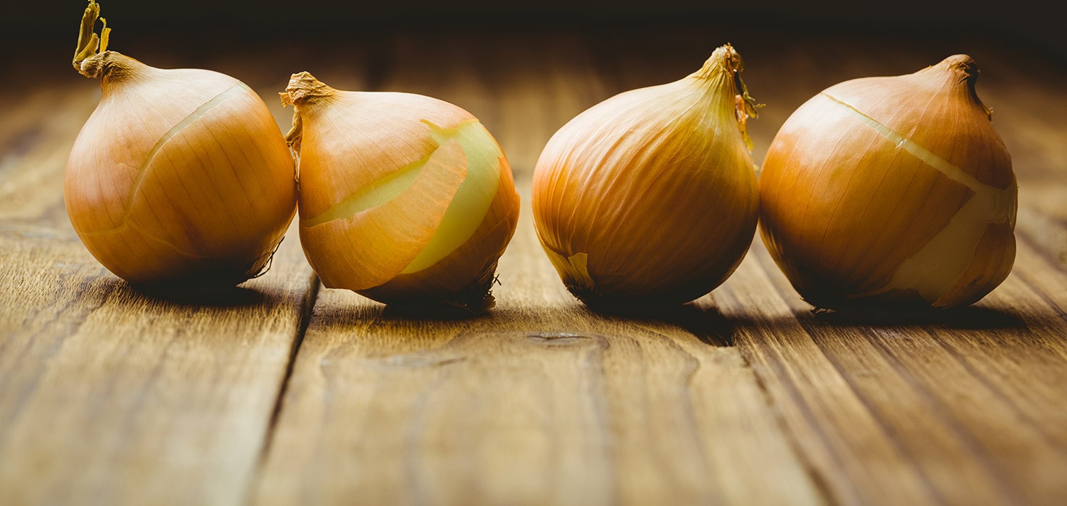 Oignons jaunes sur table en bois