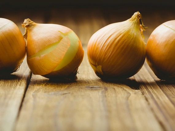 Oignons jaunes sur table en bois